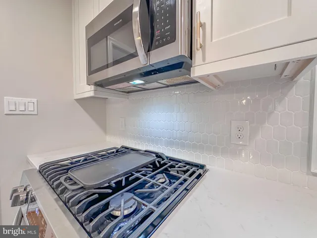 a kitchen with stainless steel appliances granite countertop a refrigerator and a stove