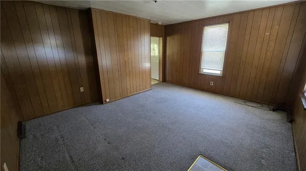 an empty room with windows and closet area