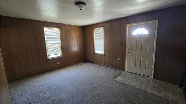 an empty room with windows and closet area