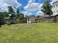 a view of a yard with wooden fence