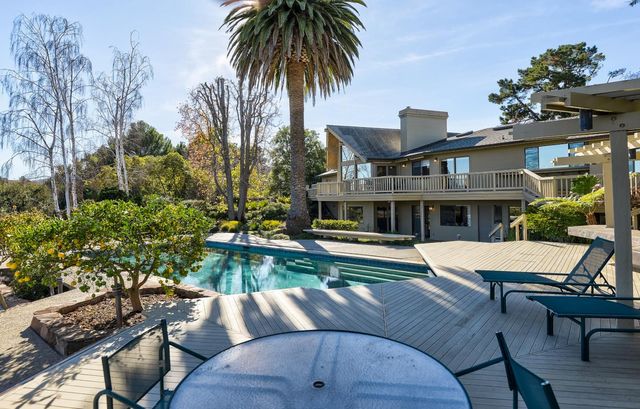 a view of a house with pool and chairs
