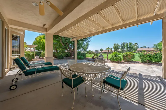 a view of a patio with a table and chairs under an umbrella