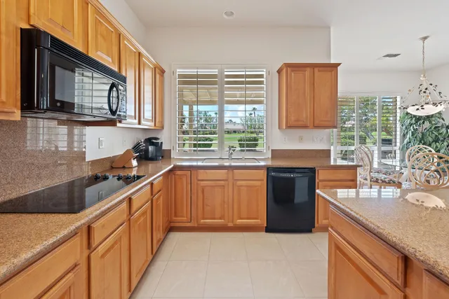 a kitchen with stainless steel appliances granite countertop a sink stove and microwave