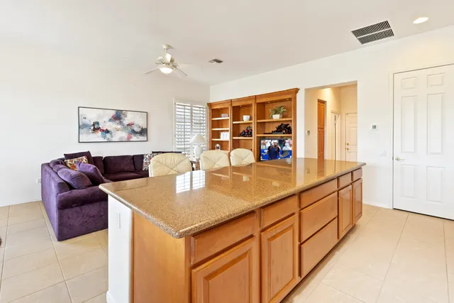 a living room with stainless steel appliances kitchen island granite countertop furniture and a large window