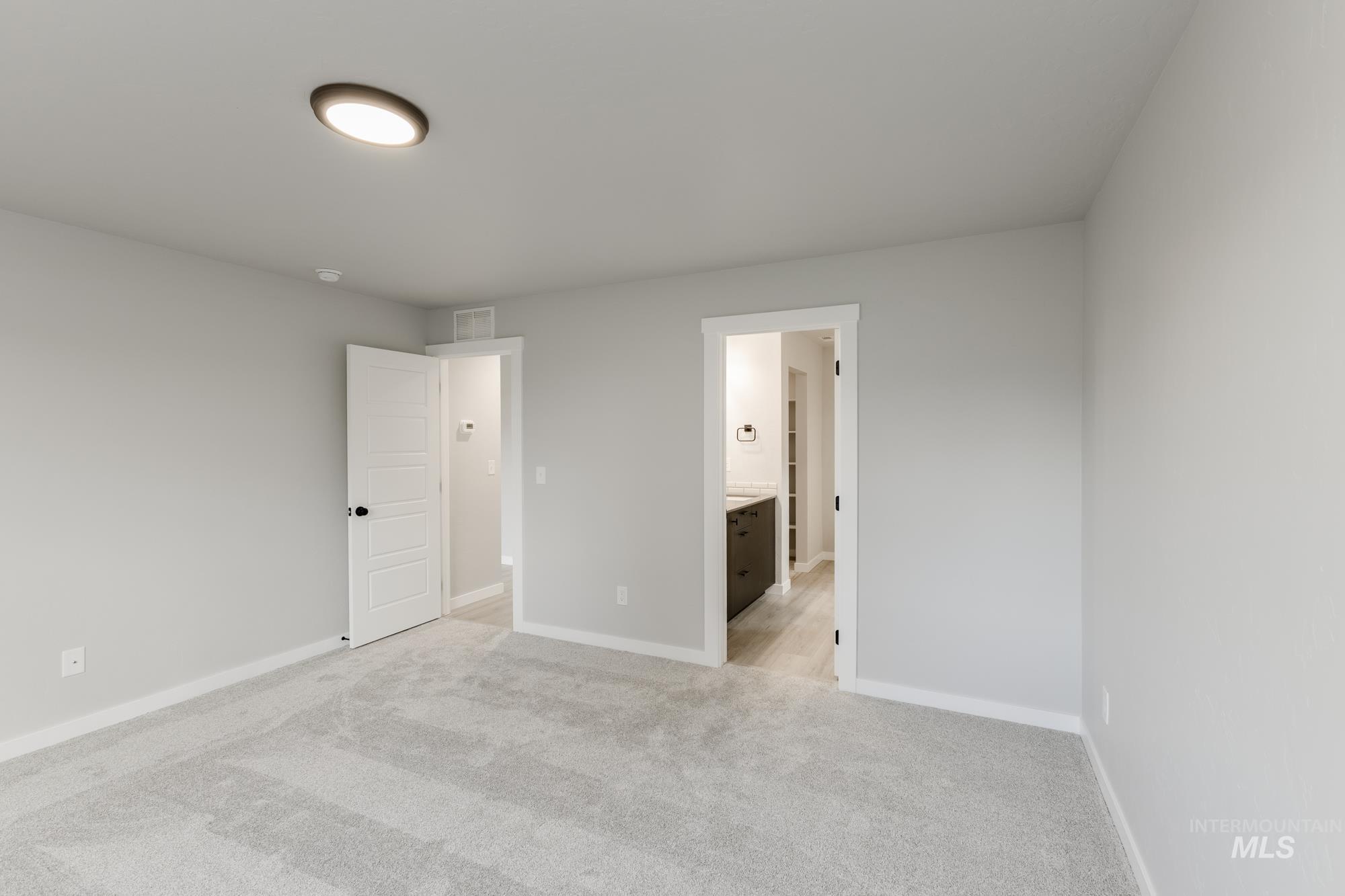 931 North Aleppo Way Meridian, ID 83642 - Photo 15 of 20 Unfurnished bedroom with light carpet and ensuite bathroom