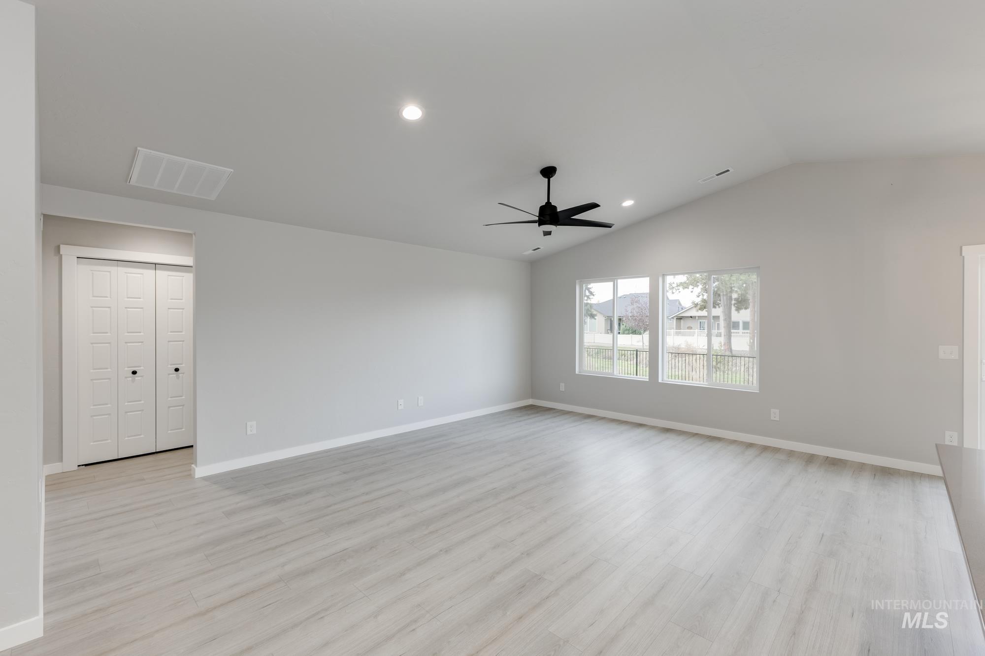 931 North Aleppo Way Meridian, ID 83642 - Photo 7 of 20 Unfurnished room with light wood finished floors, recessed lighting, vaulted ceiling, and a ceiling fan