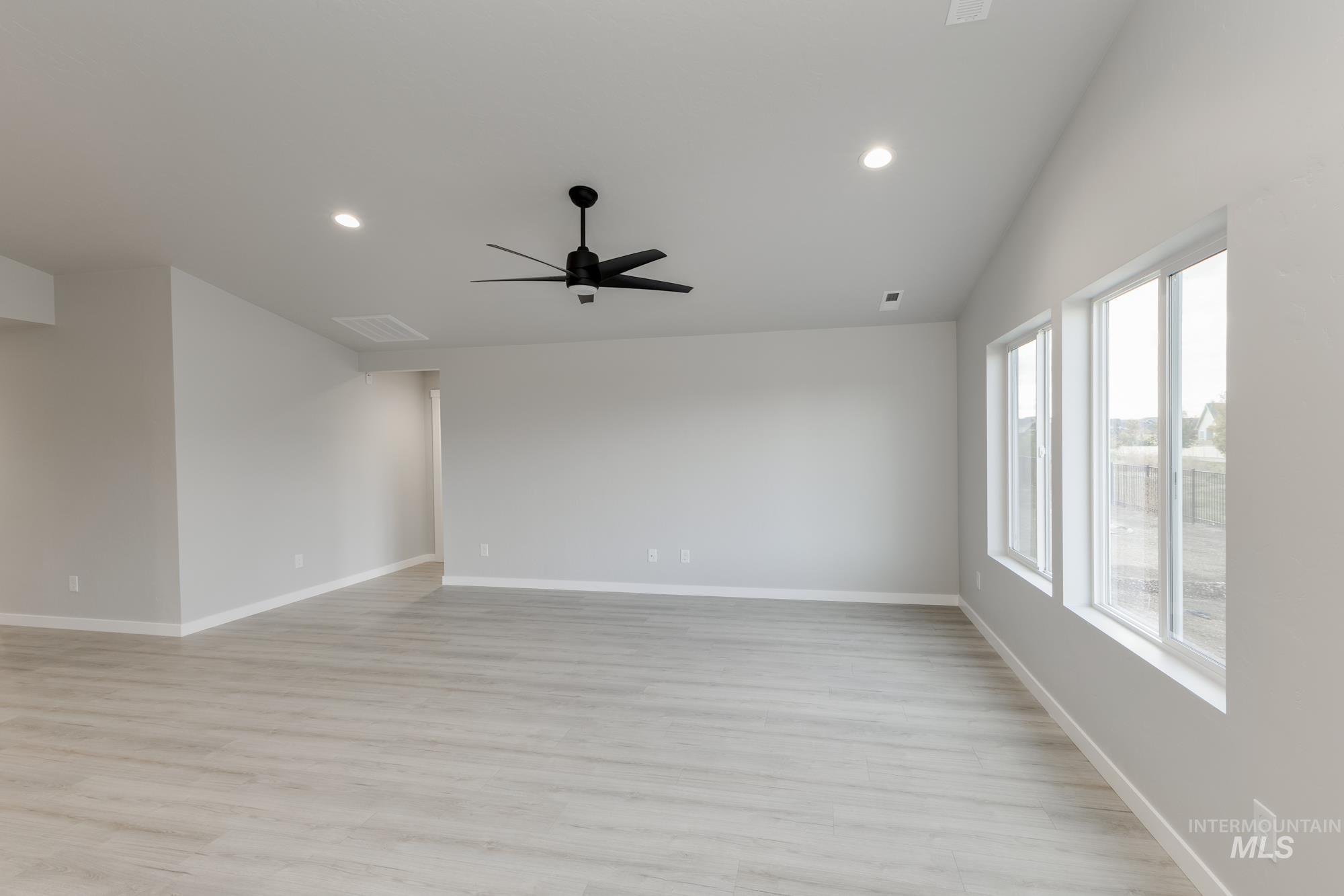 931 North Aleppo Way Meridian, ID 83642 - Photo 8 of 20 Empty room with light wood finished floors, recessed lighting, a ceiling fan, and lofted ceiling