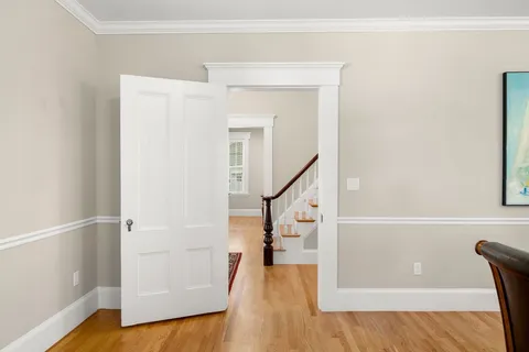 a view of a hallway with wooden floor and staircase