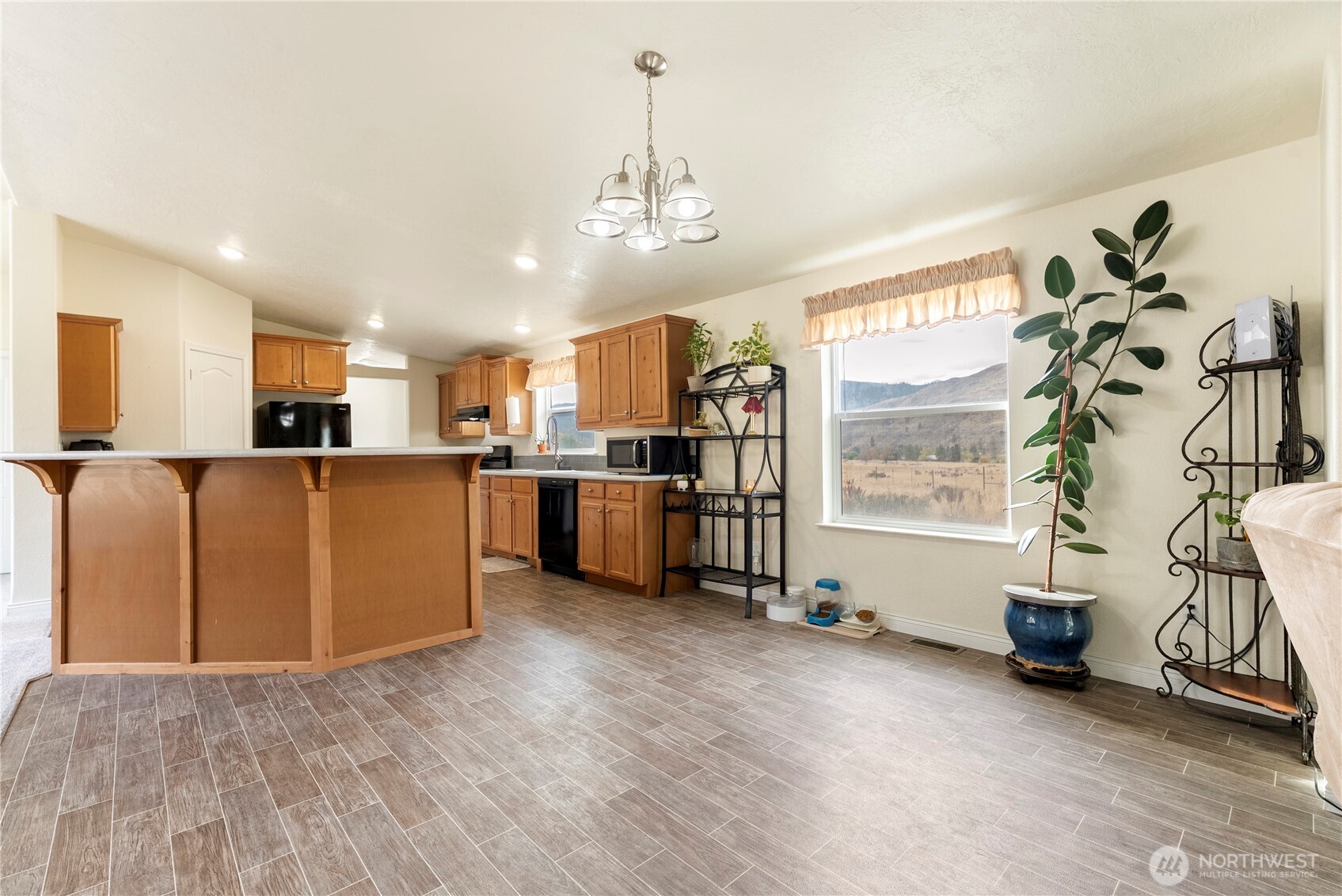 2431 Highway 153 Twisp, WA 98856 - Photo 14 of 40 a living room with stainless steel appliances kitchen island granite countertop furniture and a chandelier