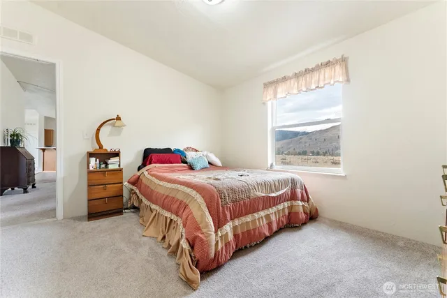 a bed sitting in a bedroom next to a window