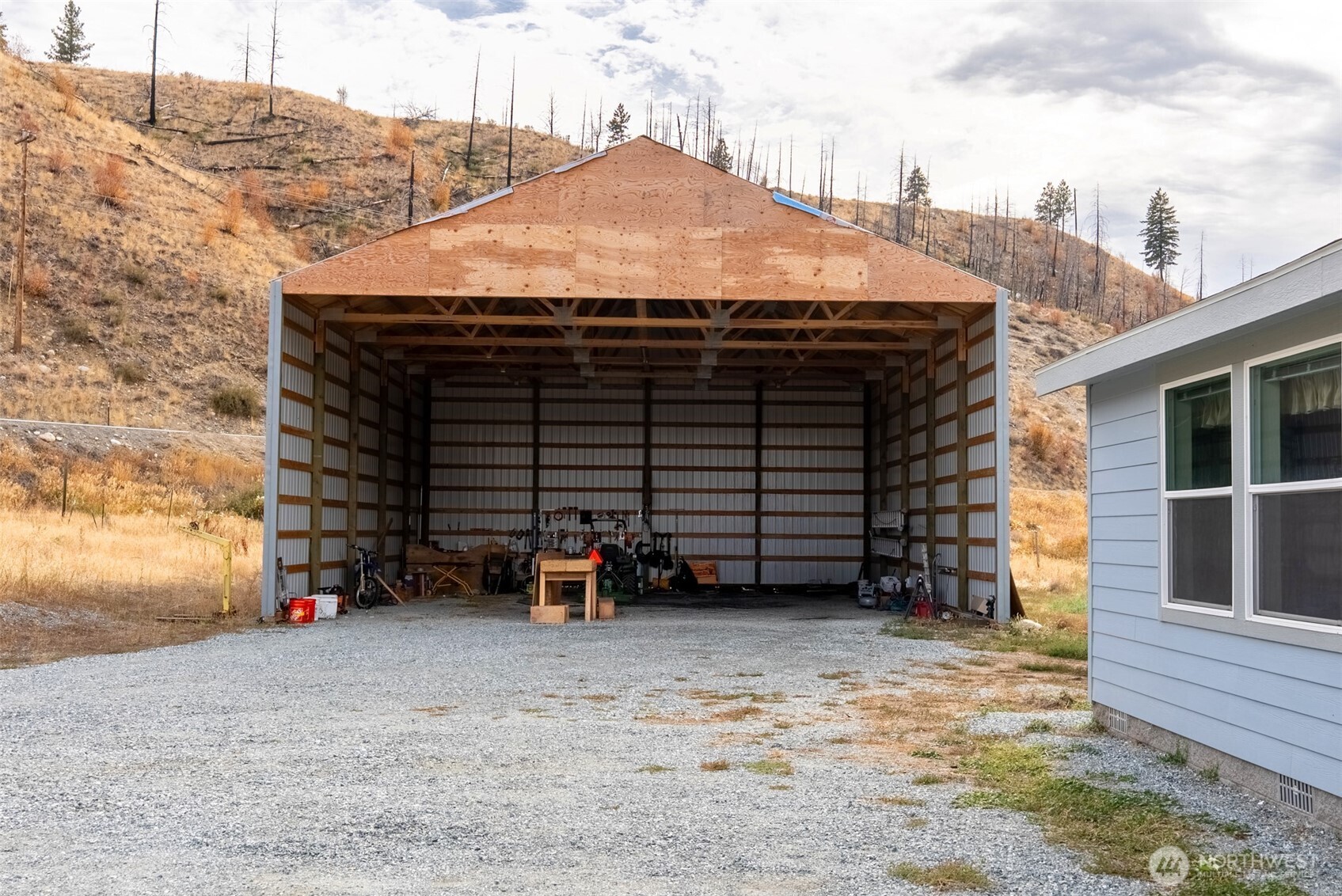 2431 Highway 153 Twisp, WA 98856 - Photo 3 of 40 a view of a house with a barbeque and wooden fence
