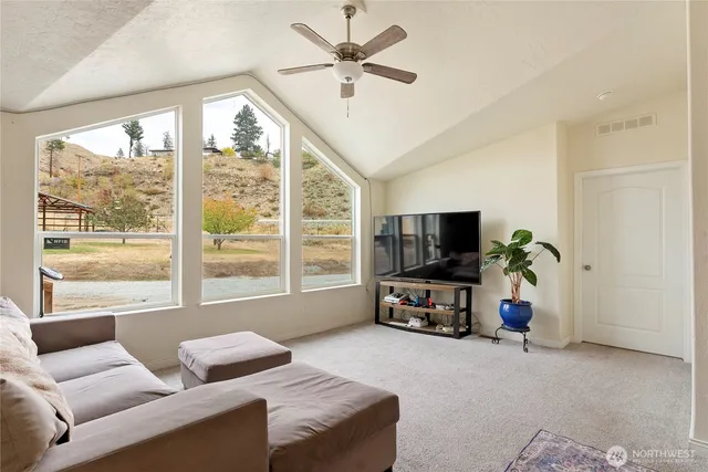 a living room with furniture a flat screen tv and a large window