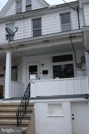 a view of a house with a car parked on the road