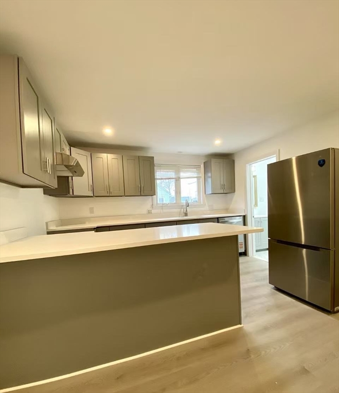 18 Howard Street, Unit 1 Waltham, MA 02451 - Photo 2 of 12 a kitchen with stainless steel appliances granite countertop a refrigerator a stove and a sink