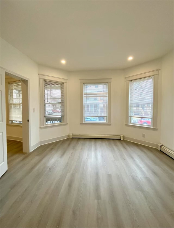 18 Howard Street, Unit 1 Waltham, MA 02451 - Photo 6 of 12 a view of an empty room with a window and wooden floor