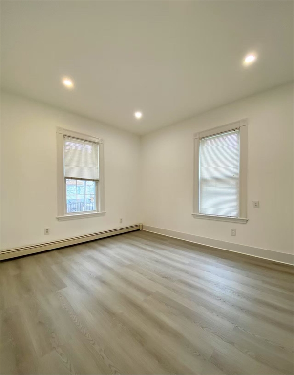 18 Howard Street, Unit 1 Waltham, MA 02451 - Photo 7 of 12 an empty room with wooden floor and windows