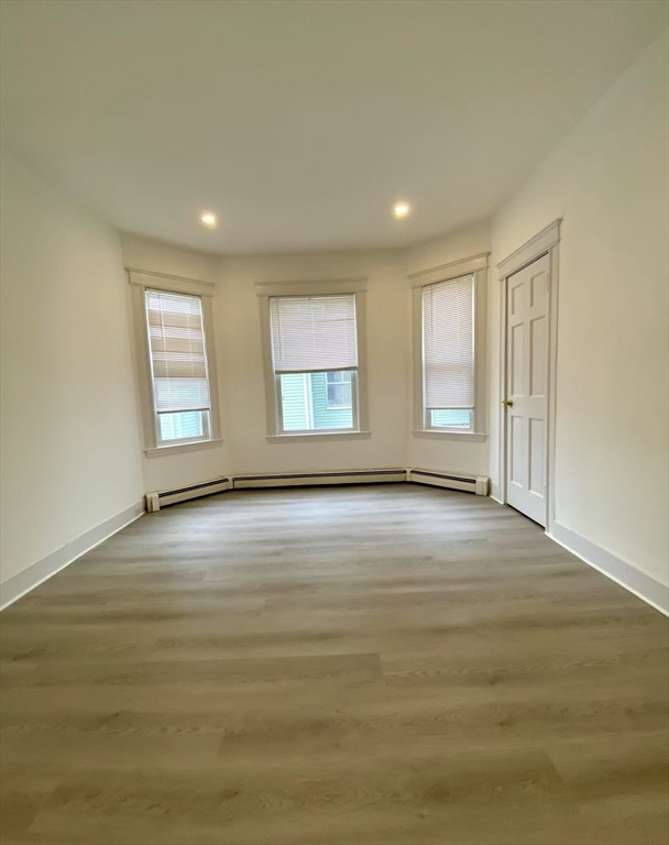 18 Howard Street, Unit 1 Waltham, MA 02451 - Photo 8 of 12 an empty room with wooden floor and windows