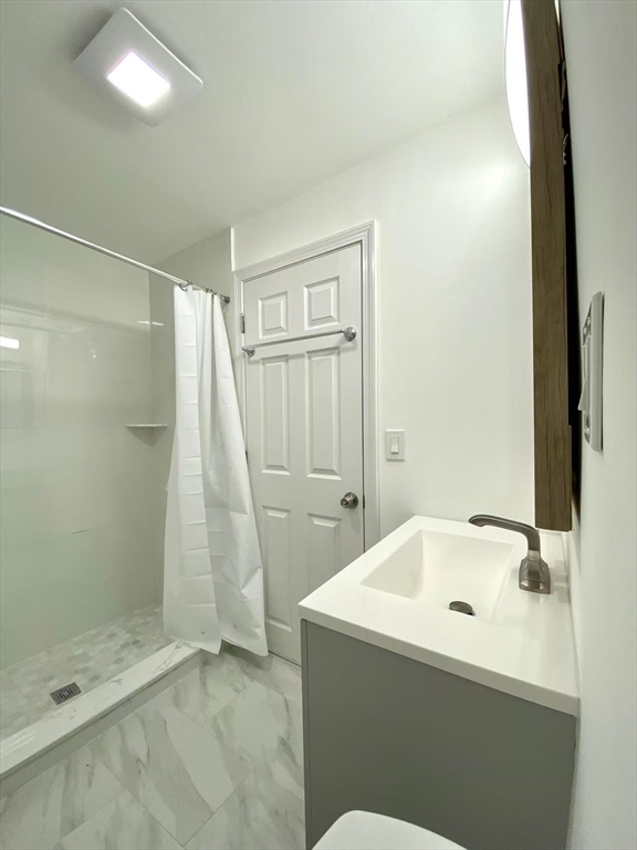 18 Howard Street, Unit 1 Waltham, MA 02451 - Photo 9 of 12 a bathroom with a sink and a shower