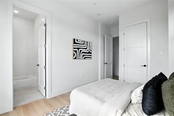 a bedroom with a bed and a painting on the wall