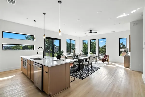 a large kitchen with stainless steel appliances granite countertop a lot of counter space and wooden floors