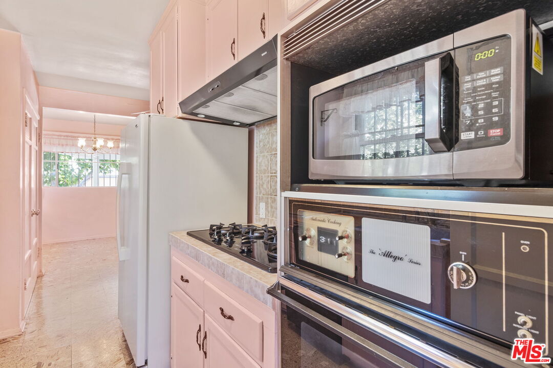 6900 Corbin Avenue Reseda, CA 91335 - Photo 13 of 35 a kitchen with stainless steel appliances granite countertop a stove and a microwave