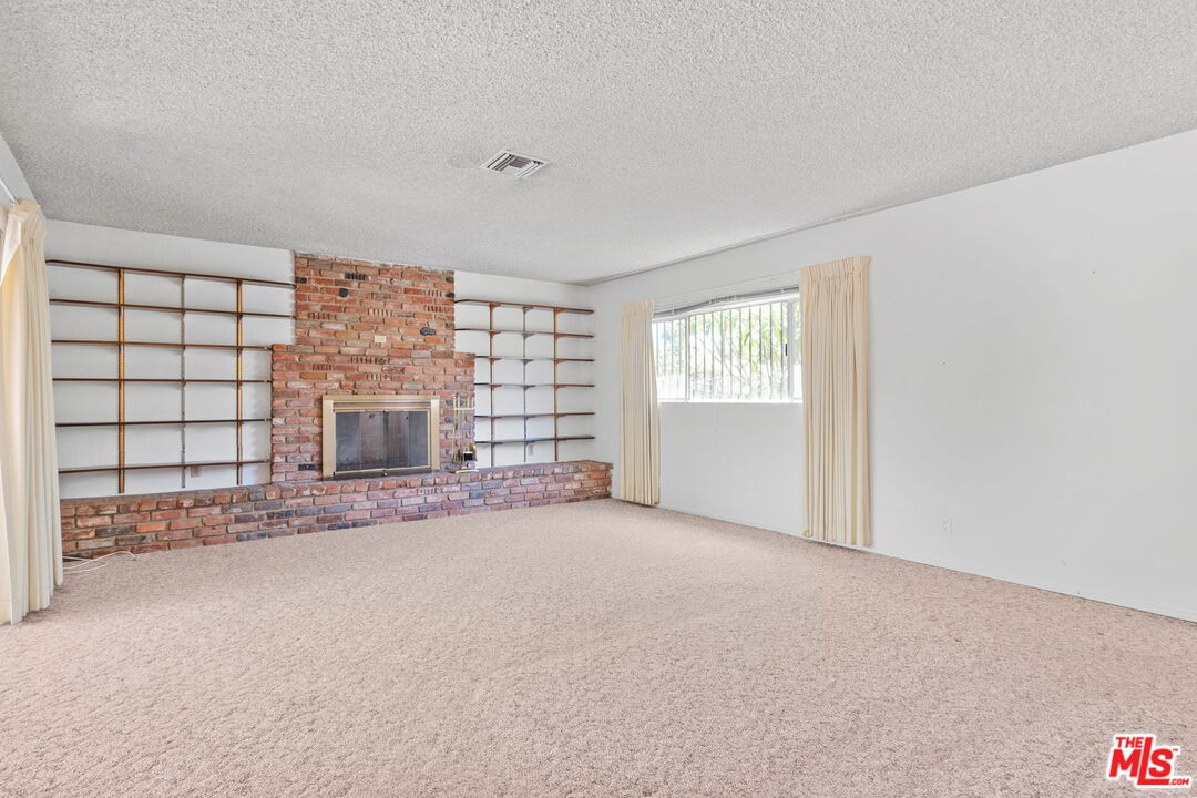 6900 Corbin Avenue Reseda, CA 91335 - Photo 17 of 35 a view of an empty room with a fireplace and a window