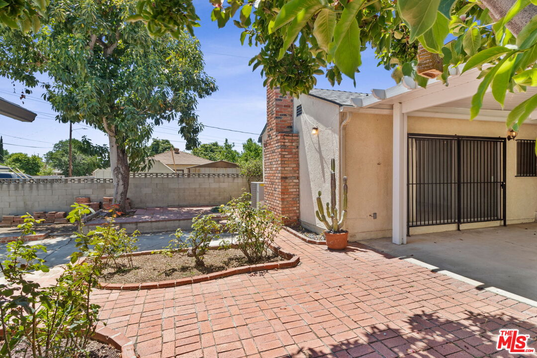 6900 Corbin Avenue Reseda, CA 91335 - Photo 26 of 35 a front view of a house with a yard and a garden