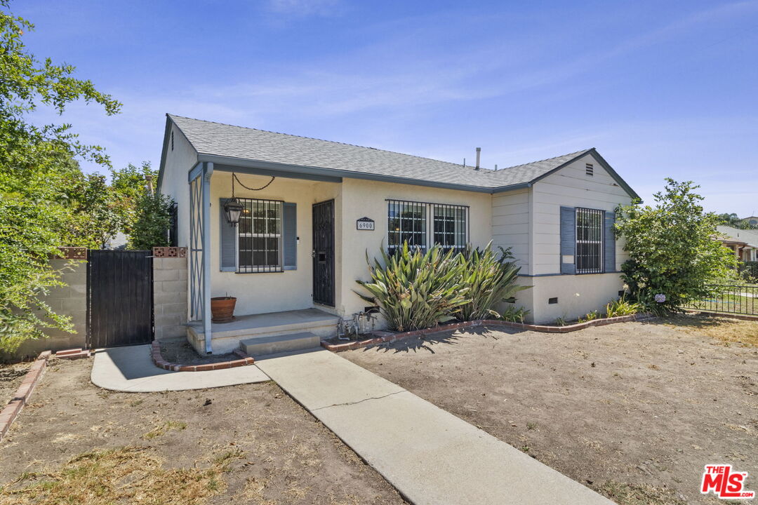 6900 Corbin Avenue Reseda, CA 91335 - Photo 4 of 35 a front view of a house with a yard and potted plants
