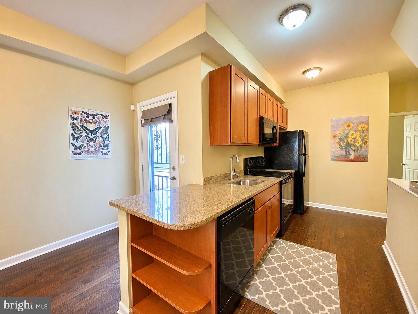 1618 Page Street, Unit A Philadelphia, PA 19121 - Photo 1 of 21 a kitchen with kitchen island granite countertop a sink appliances cabinets and wooden floor