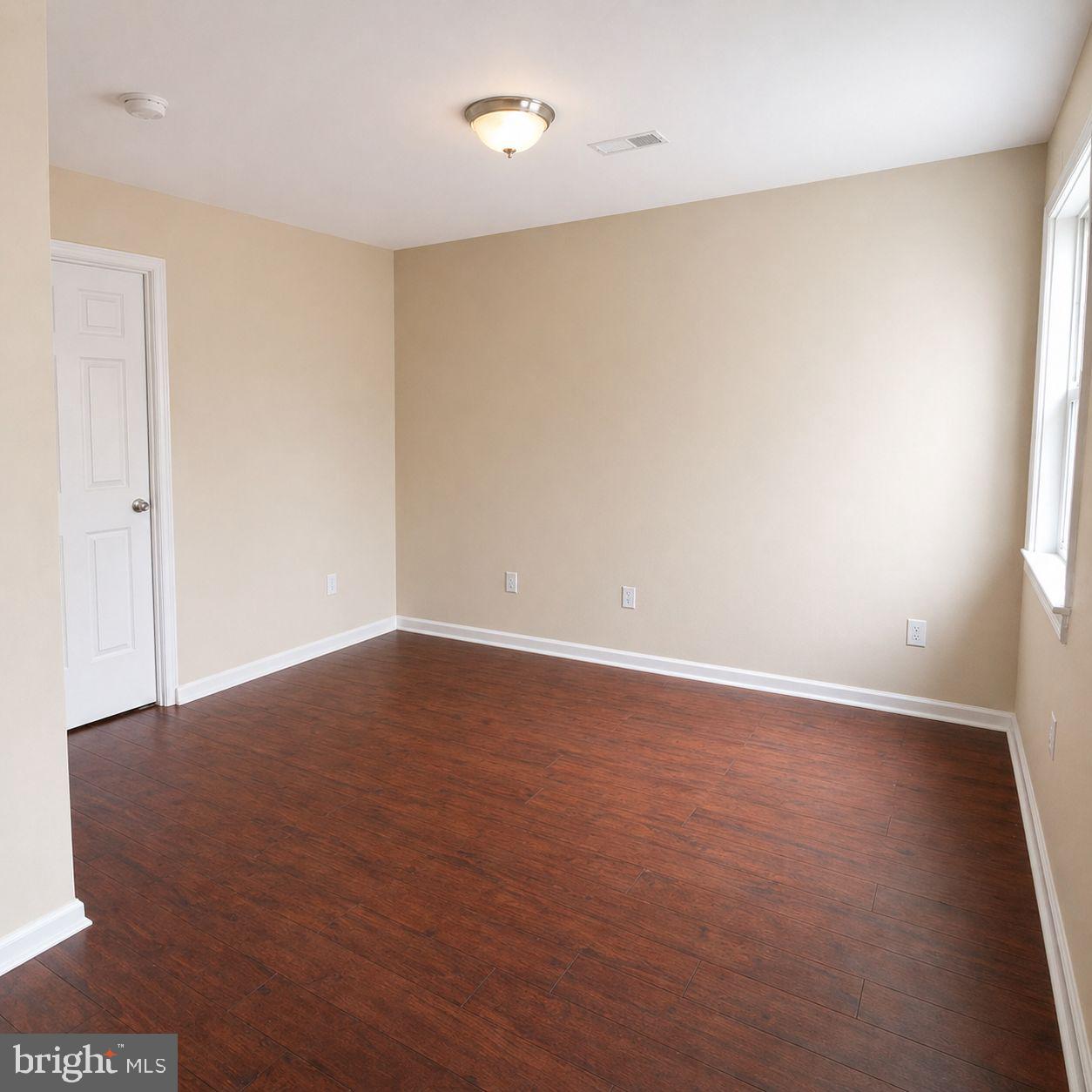 1618 Page Street, Unit A Philadelphia, PA 19121 - Photo 14 of 21 an empty room with wooden floor and windows