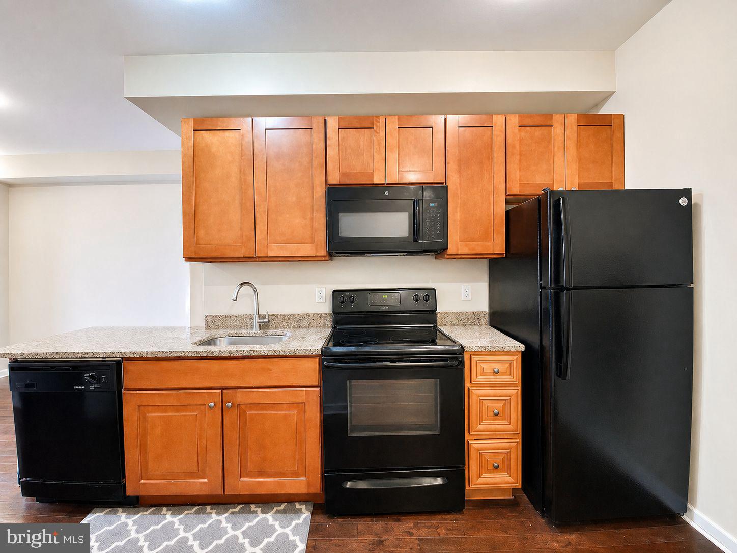 1618 Page Street, Unit A Philadelphia, PA 19121 - Photo 3 of 21 a kitchen with granite countertop a refrigerator stove and sink