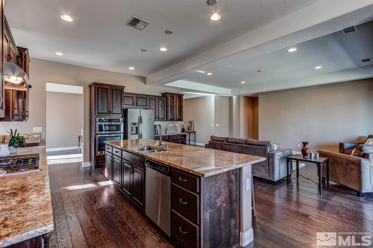 10060 Gold Cup Lane Reno, NV 89521 - Photo 9 of 25 a open kitchen with stainless steel appliances granite countertop a table chairs and a refrigerator