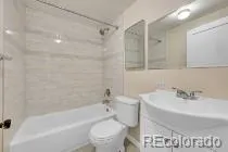 a bathroom with a bathtub shower sink vanity and toilet