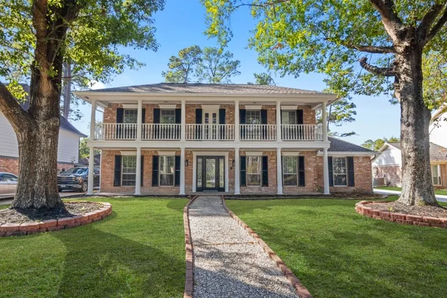 a view of a house with a yard and potted plants