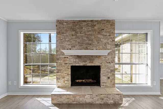 a living room with a fireplace and windows