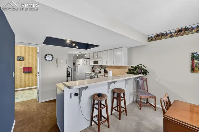 a kitchen with white cabinets appliances and sink