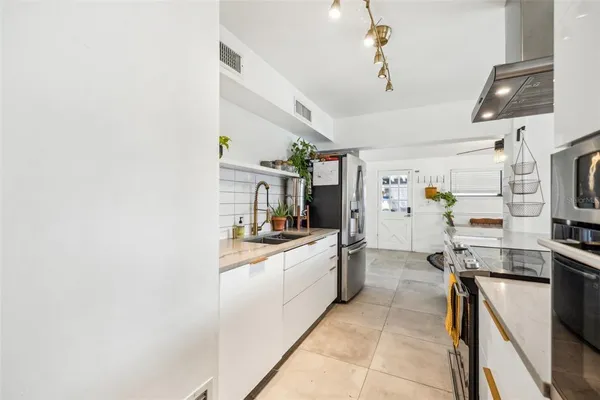 a kitchen with stainless steel appliances a stove refrigerator and a microwave