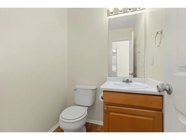 a bathroom with a granite countertop toilet sink and mirror