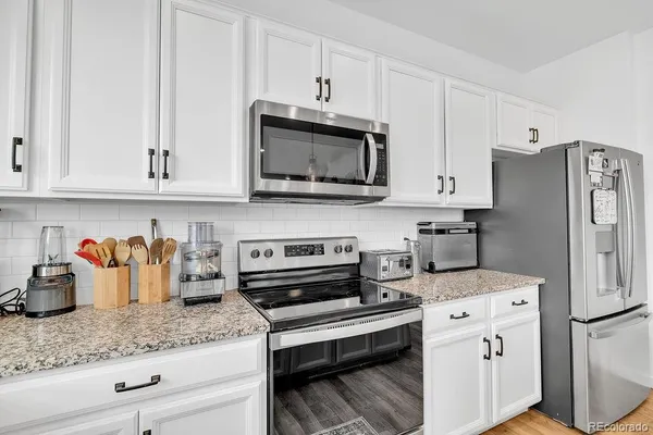 a kitchen with stainless steel appliances granite countertop a refrigerator sink and cabinets