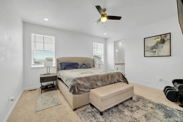 a spacious bedroom with a bed a couch and a window
