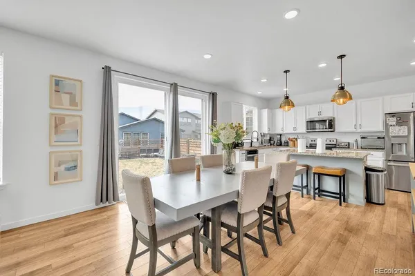 a kitchen with a table chairs refrigerator and cabinets