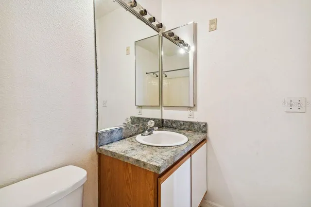 a bathroom with a granite countertop sink and a mirror