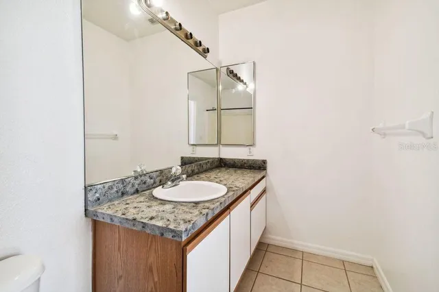 a view of a hallway with a livingroom and a bathroom with a sink