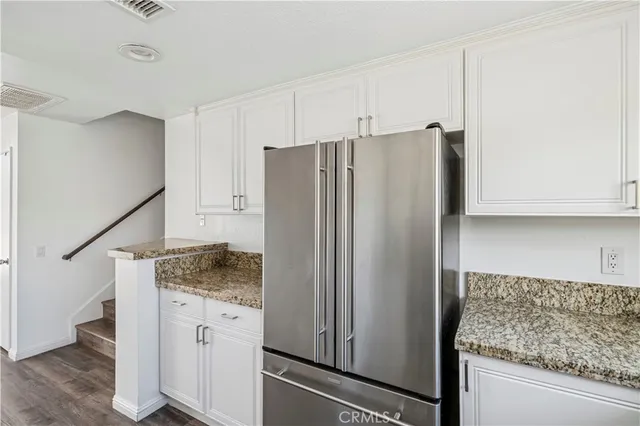 a kitchen with granite countertop cabinets and refrigerator