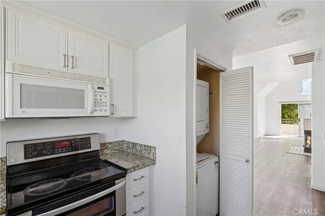 a kitchen with stainless steel appliances a stove and white cabinets