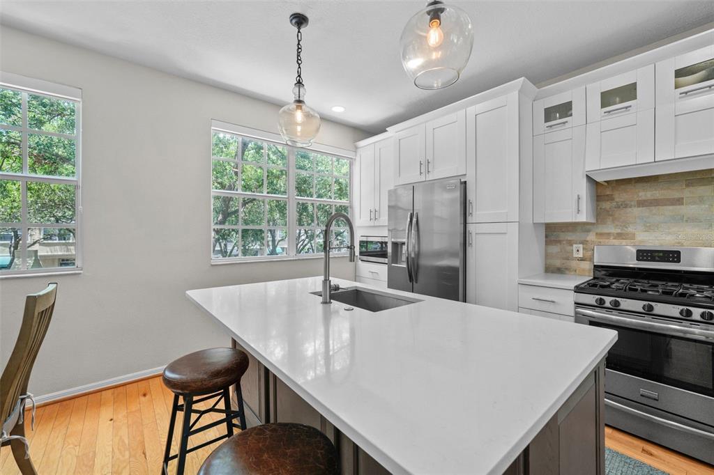 1451 Harbour Walk Road Tampa, FL 33602 - Photo 8 of 51 a kitchen with stainless steel appliances a table chairs and refrigerator