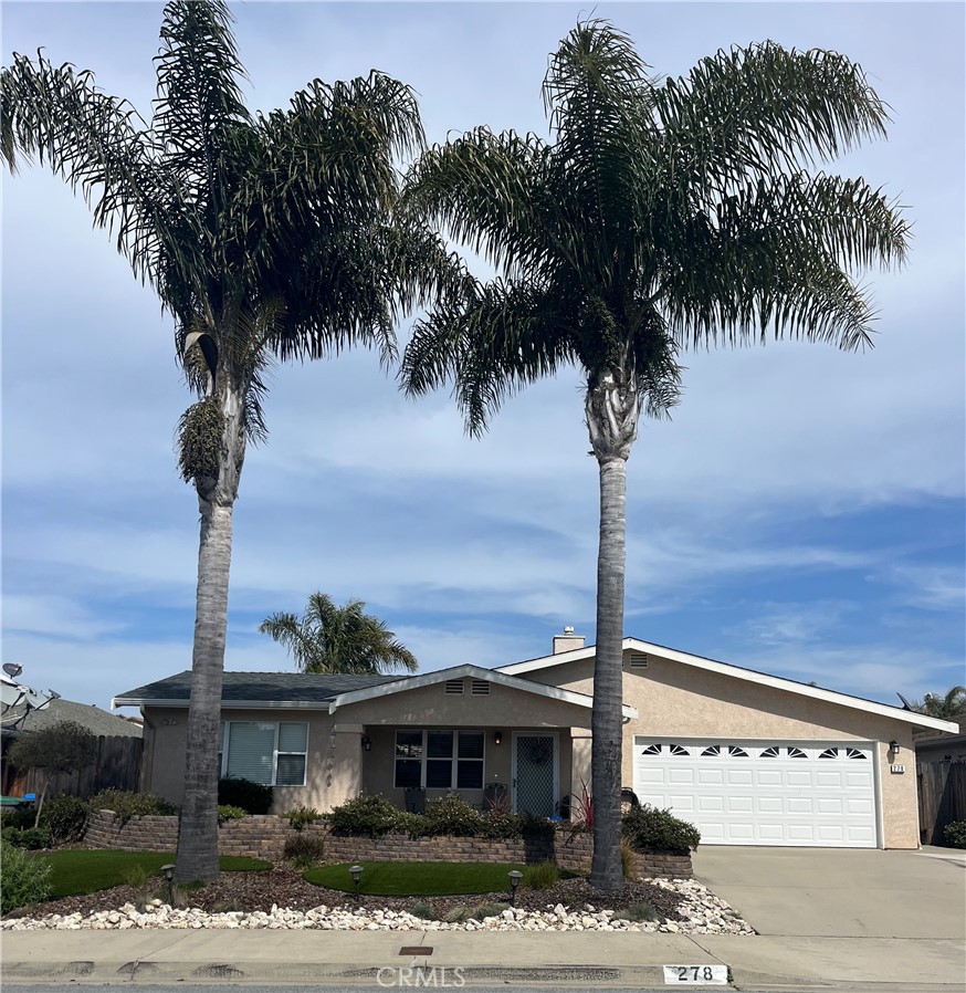 a front view of a house with yard and tree s