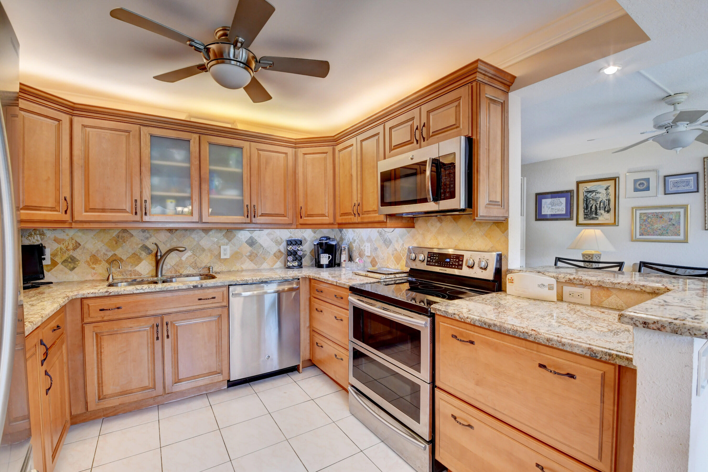 1045 Wolverton C, Unit 1045 Boca Raton, FL 33434 - Photo 11 of 67 a kitchen with granite countertop appliances cabinets a sink and a counter top space