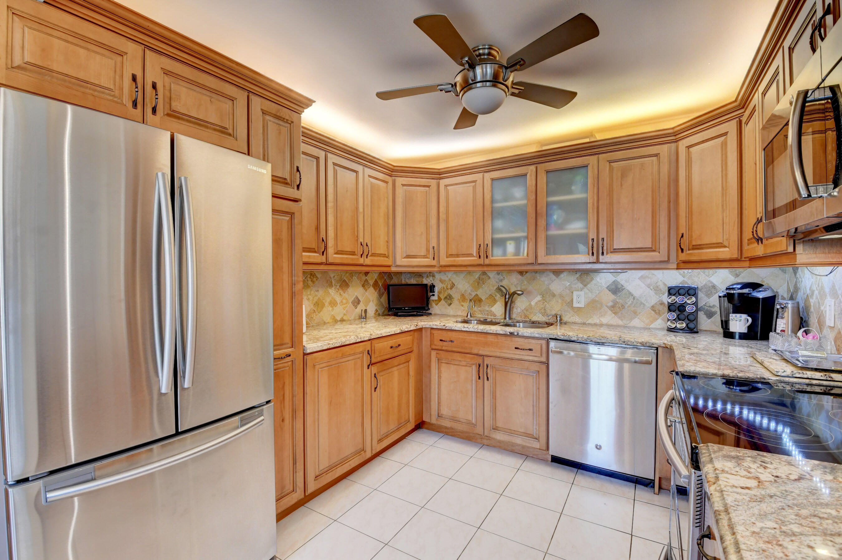 1045 Wolverton C, Unit 1045 Boca Raton, FL 33434 - Photo 12 of 67 a kitchen with stainless steel appliances granite countertop a refrigerator and a stove top oven