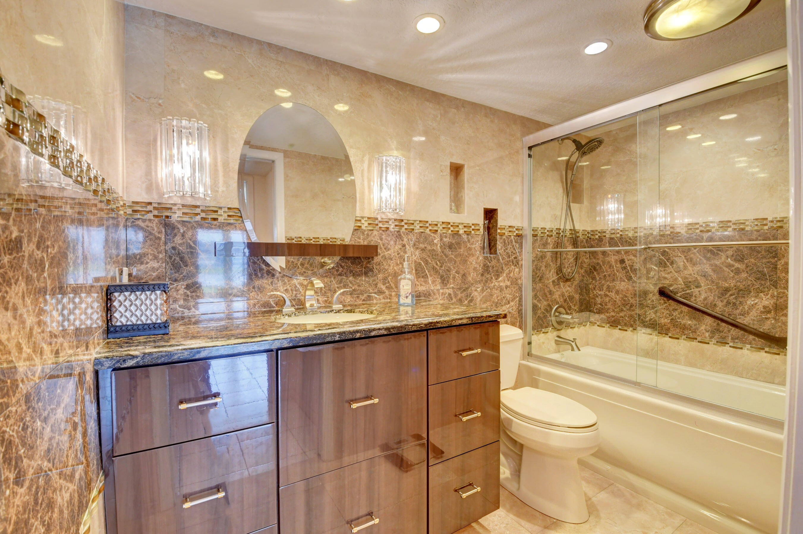 1045 Wolverton C, Unit 1045 Boca Raton, FL 33434 - Photo 15 of 67 a bathroom with a granite countertop sink a toilet and bathtub